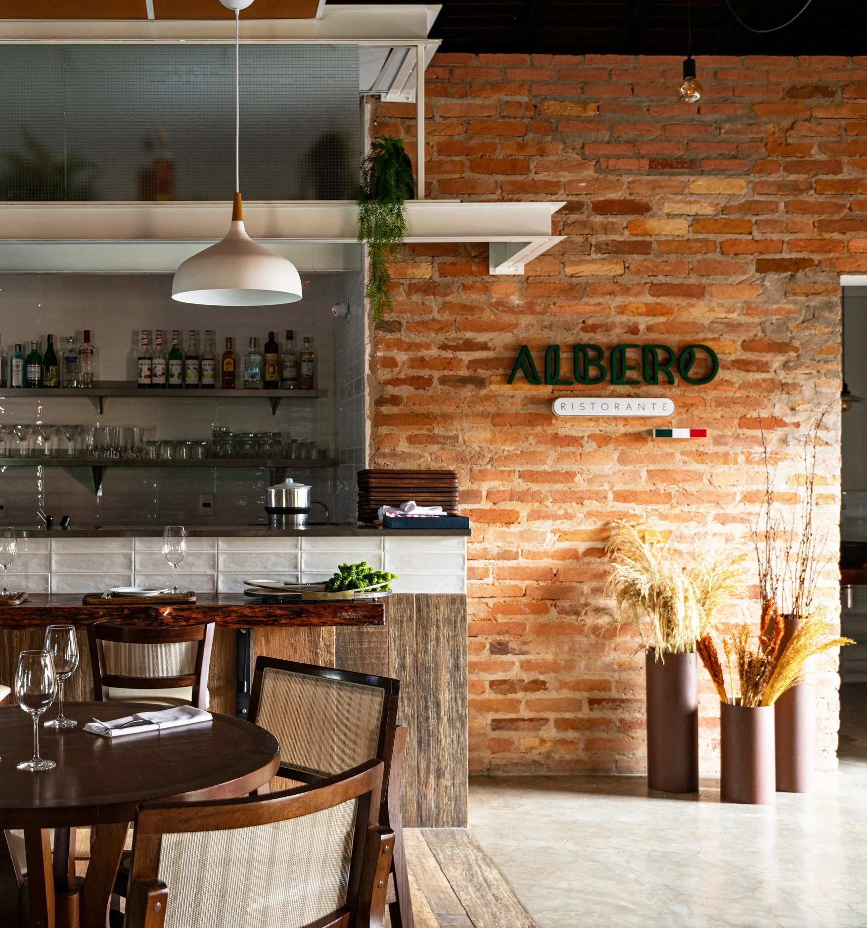 Gastrobar em madeira, tijolo e estrutura metálica suspensa