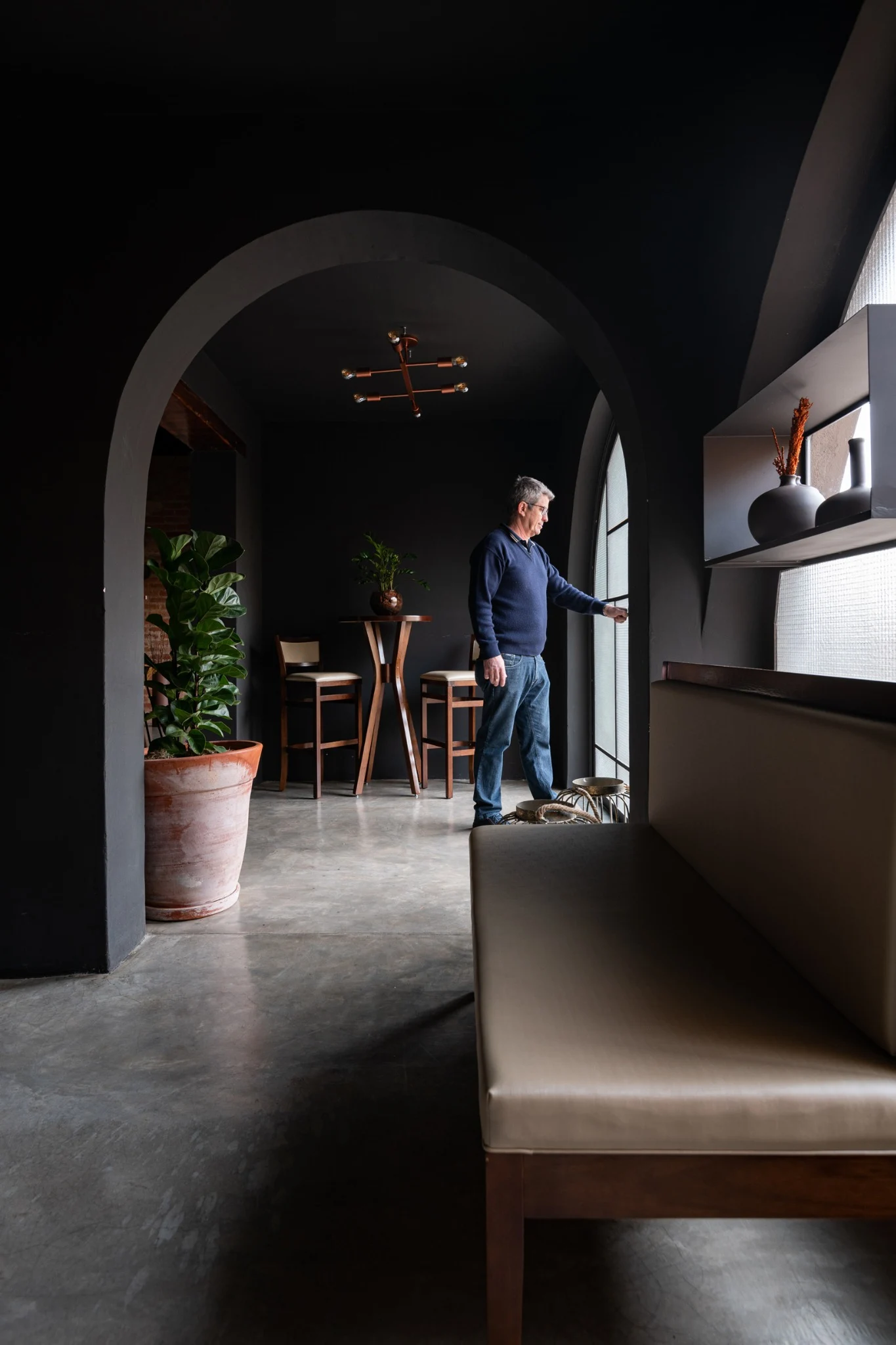 Sequência de arcos e planos escuros na entrada do restaurante